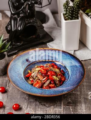 mixed tomatoes and meat in blue plate Stock Photo