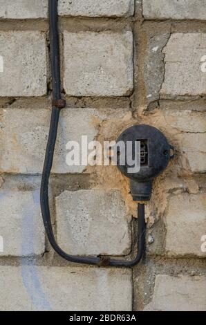 Old electric switch on the wall. Worn out switch on a brick wall. Occupational safety at production. Insurance and security. Close-up. Selective focus Stock Photo