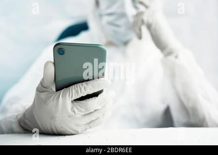Woman person protects herself from a global pandemic and holds a phone in her hands. Stock Photo