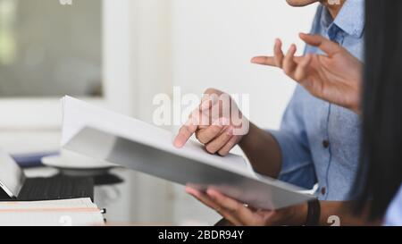 Cropped image of Business development team discussing/meeting about their business profit result while holding a document file and sitting at the mode Stock Photo