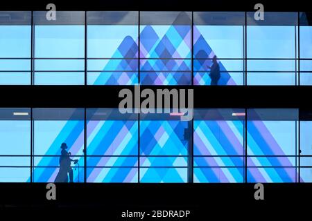 A person walks on a bridge in front of the Mount Sinai logo at Mt. Sinai Hospital in New York, USA - 02 Apr 2020 Stock Photo
