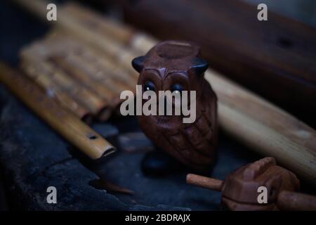 Handmade wooden owl whistle in dark brown color. Stock Photo
