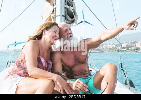 Senior couple on sailboat vacation - Happy mature lovers having fun celebrating wedding anniversary on boat trip Stock Photo