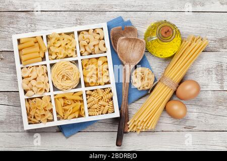 Various pasta in wooden box. Top view flat lay Stock Photo