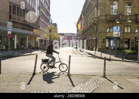 Old Man Riding Bicycle on Empty Street in Frankfurt During Lockdown Stock Photo