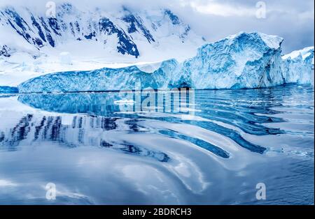 Iceberg Reflection Abstract Snow Mountains Blue Glaciers Dorian Bay Antarctic Peninsula Antarctica.  Glacier ice blue because air squeezed out of snow Stock Photo