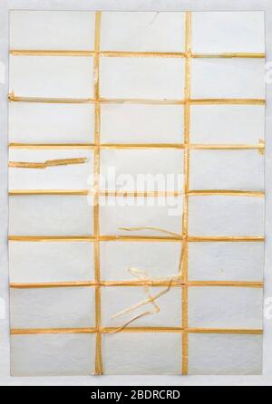 Multiple folded paper with visible scraps of old adhesive tape on white background Stock Photo
