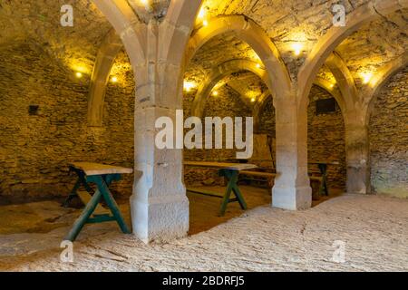 Dining room in medieval arched vault with furniture and columns Stock Photo