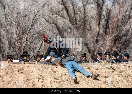 Union Army soldier and 'dead' Confederate Army soldier on fortified mound, Civil War reenactment, near Socorro, New Mexico USA Stock Photo