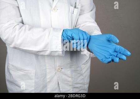 Female doctor wearing blue medical gloves. Studio photo over black background. Stock Photo