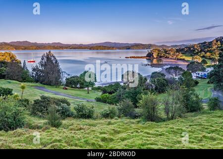 Campground at Puriri Bay, Whangaruru Harbour at sunrise, near village of Whangaruru North, Northland Region, North Island, New Zealand Stock Photo