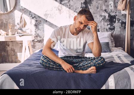 Serious young male person being deep in thoughts Stock Photo