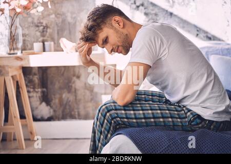 Serious young bearded man being deep in thoughts Stock Photo