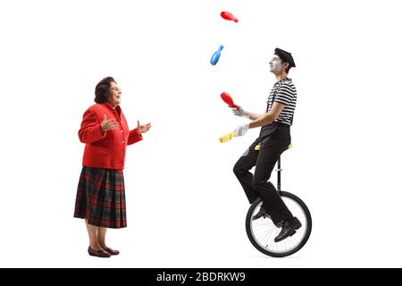 Elderly man a riding a unicycle and juggling isolated on white ...