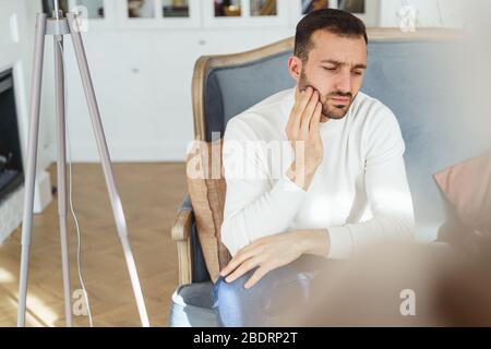 Young Caucasian man suffering from a toothache Stock Photo