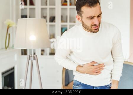 Caucasian male suffering from severe stomach spasms Stock Photo
