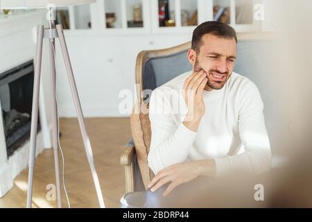 Frustrated short-haired young man having a toothache Stock Photo
