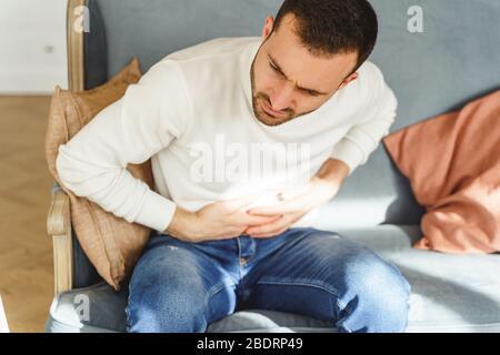 Young man writhing in a stomach pain Stock Photo