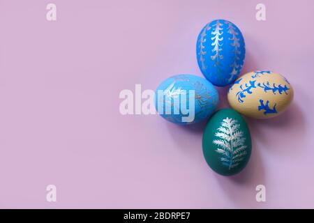 four colored easter eggs on a pink background top view. horizontal image with copy space. Stock Photo