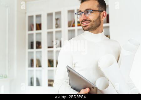 Pleased young Caucasian engineer wearing trendy eyeglasses Stock Photo