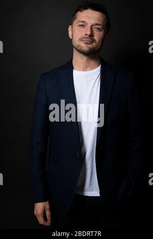 Attractive caucasian man seductively looking at camera, holding hand in pocket Stock Photo