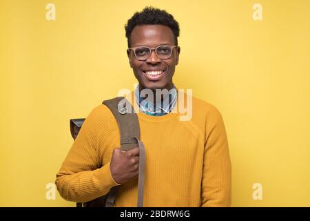 college student holding backpack and smiling being glad to study Stock Photo