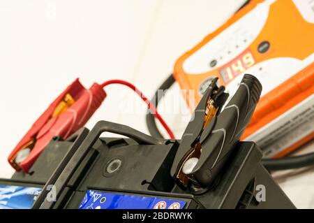 Recharging the car battery with red and black copper clips attached to the terminals Stock Photo