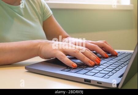 Close-up of woman's hands typing on laptop computer. Stock Photo