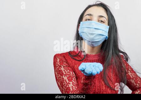 A young middle-eastern woman wearing evening dress and surgical mask. Beauty female in surgical mask celebrating. Portrait of middle-aged lady having Stock Photo