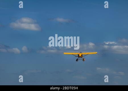 Small yellow seaplane in flight Stock Photo