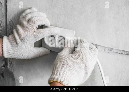 Work on the installation of electrical outlets. The wizard replaces the old outlet with a new one. Copy space. Stock Photo