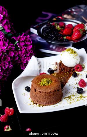 small chocolate cake garnished with pistachio served with vanilla ice cream Stock Photo