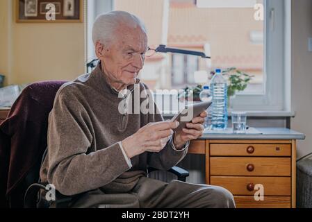 Positive Senior using Digital Tablet Stock Photo