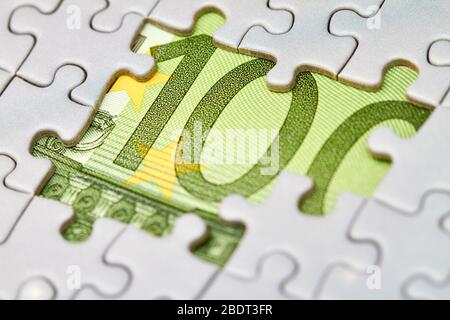 Euro puzzle, business concept of solution. One hundred euro bill and puzzle pieces. Closeup, selective focus Stock Photo