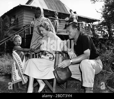 CLARK GABLE and GRACE KELLY on set location candid with young African girl during filming of MOGAMBO 1953 director JOHN FORD screenplay John Lee Mahin play Wilson Collison Metro Goldwyn Mayer Stock Photo