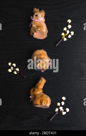 chocolate willow branches and cute bunnies on wooden background, happy Easter greeting card, spring festive season. Flat lay, top view Stock Photo