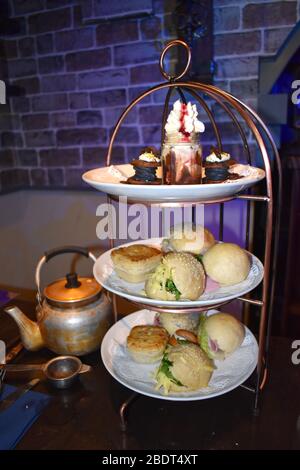 Afternoon tea at central London. Selection of sandwiches leek and potato pie Yorkshire pudding served with roast beef rock cakes butterscotch biscuits Stock Photo