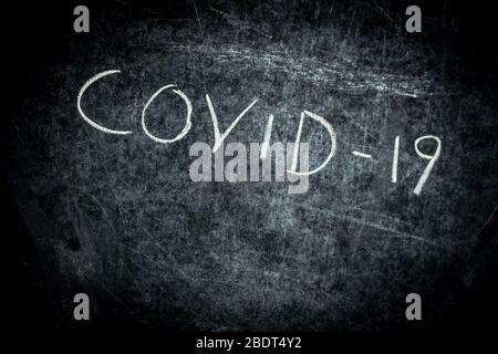 Coronavirus, Covid-19 drawn text with chalk on blackboard. Stock Photo