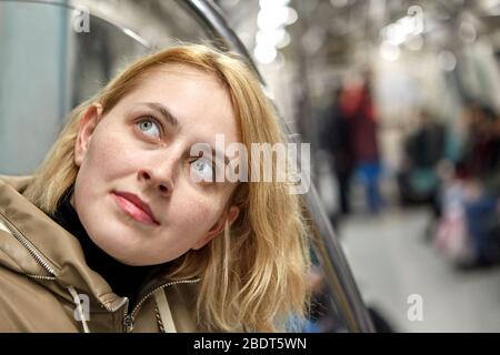 Young pretty white caucasian woman with blond hair is sitting in the subway car in Istanbul. Stock Photo