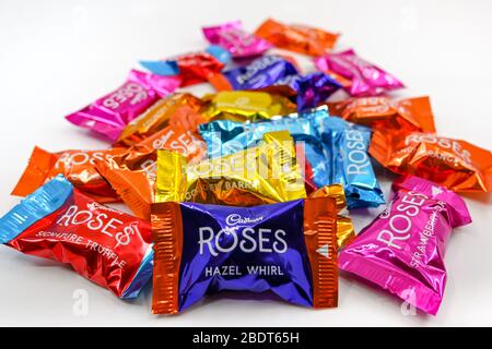 CARDIFF, WALES - DECEMBER 2019: Close up of a selection of wrapped Cadburys Roses chocolates on a plain white background Stock Photo