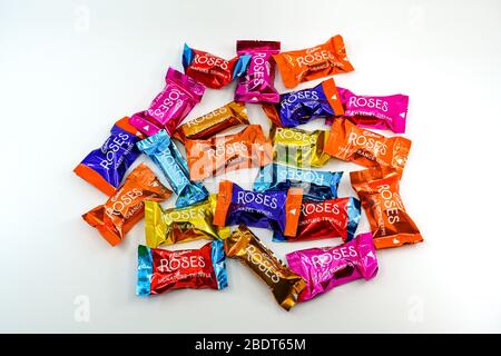 CARDIFF, WALES - DECEMBER 2019: Close up of a selection of wrapped Cadburys Roses chocolates on a plain white background Stock Photo