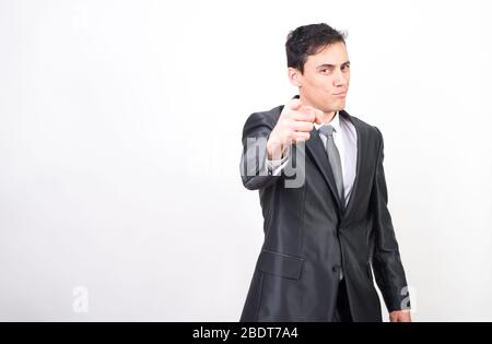 Man in suit pointing in front with index finger. White background, Medium shot Stock Photo