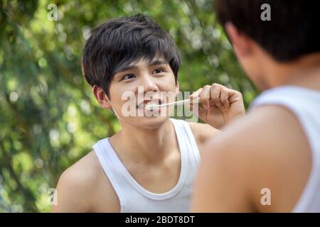 Outdoor young man brushing your teeth in front of a mirror Stock Photo