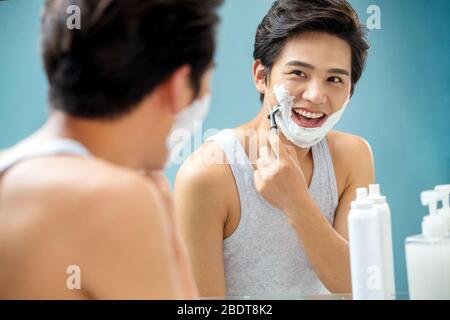 The young man in front of a mirror to shave Stock Photo