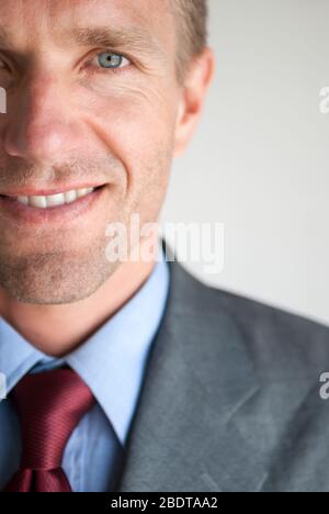 Smiling close-up portrait of friendly businessman looking at the camera in a head and shoulders close-up Stock Photo