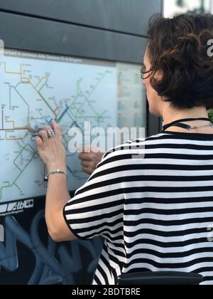 Traveller girl wear white t-shirt with black stripes looking the map Stock Photo