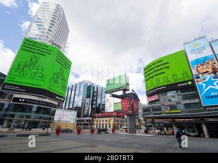Toronto, Canada. 9th Apr, 2020. A man wearing a face mask looks at screens displaying the Ontario government's messages on COVID-19 at Yonge-Dundas Square in Toronto, Canada, on April 9, 2020. Canada could see 22,580 to 31,850 COVID-19 cases and 500 to 700 deaths by April 16, the Public Health Agency of Canada said Thursday. Credit: Zou Zheng/Xinhua/Alamy Live News Stock Photo