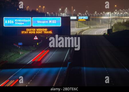 Glasgow, UK. 9th Apr, 2020. Pictured: Road signs all along the M8 and M80 motorways which read, “EASTER WEEKEND STAY HOME DONT TRAVEL” The Coronavirus Pandemic has forced the UK Government to order a shut down of all the UK major cities and make people stay at home, which has left the motorways and all other roads free of the usual nose to tail traffic which would otherwise be there. Credit: Colin Fisher/Alamy Live News Stock Photo