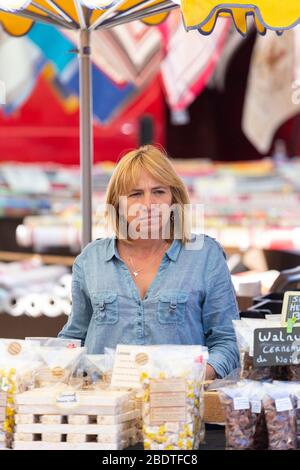 Female vendor at Man with cheese at the Menerbes market, Provence, France Stock Photo