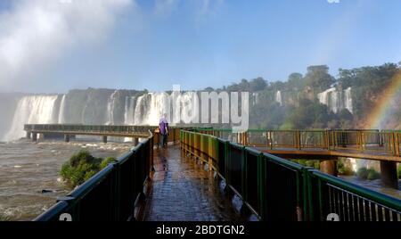 Tourist on the walkway at Devils Throat waterfall at Iguacu waterfalls, BRazil Stock Photo